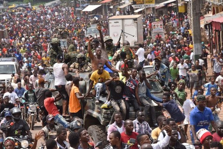 Orang-orang merayakan di jalan-jalan dengan anggota angkatan bersenjata Guinea setelah penangkapan presiden Guinea, Alpha Conde, dalam kudeta di Conakry, 5 September 2021.