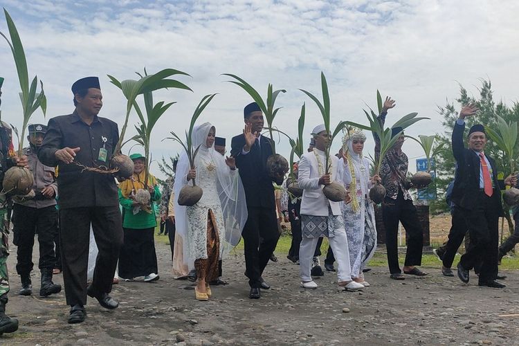 Dua pasangan pengantin menanam tunas kelapa di Pantai Bidara, pantai wisata yang berada di Gumuk Waru, Kalurahan Bugel, Kapanewon Panjatan, Kabupaten Kulon Progo, Daerah Istimewa Yogyakarta.