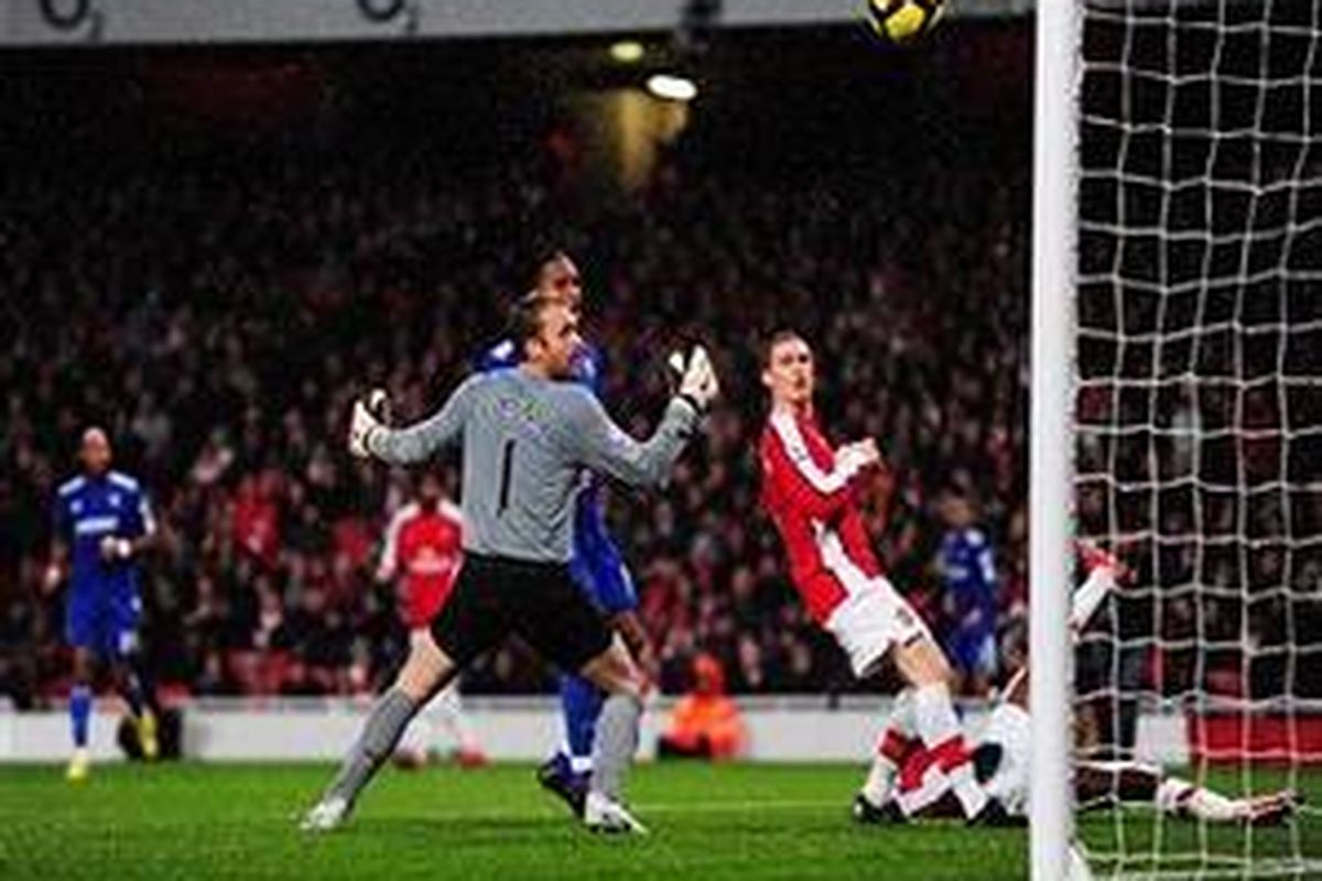 Defender Arsenal, Thomas Vermaelen, (tengah) terpana melihat tendangannya justru menjebol gawang timnya sendiri.