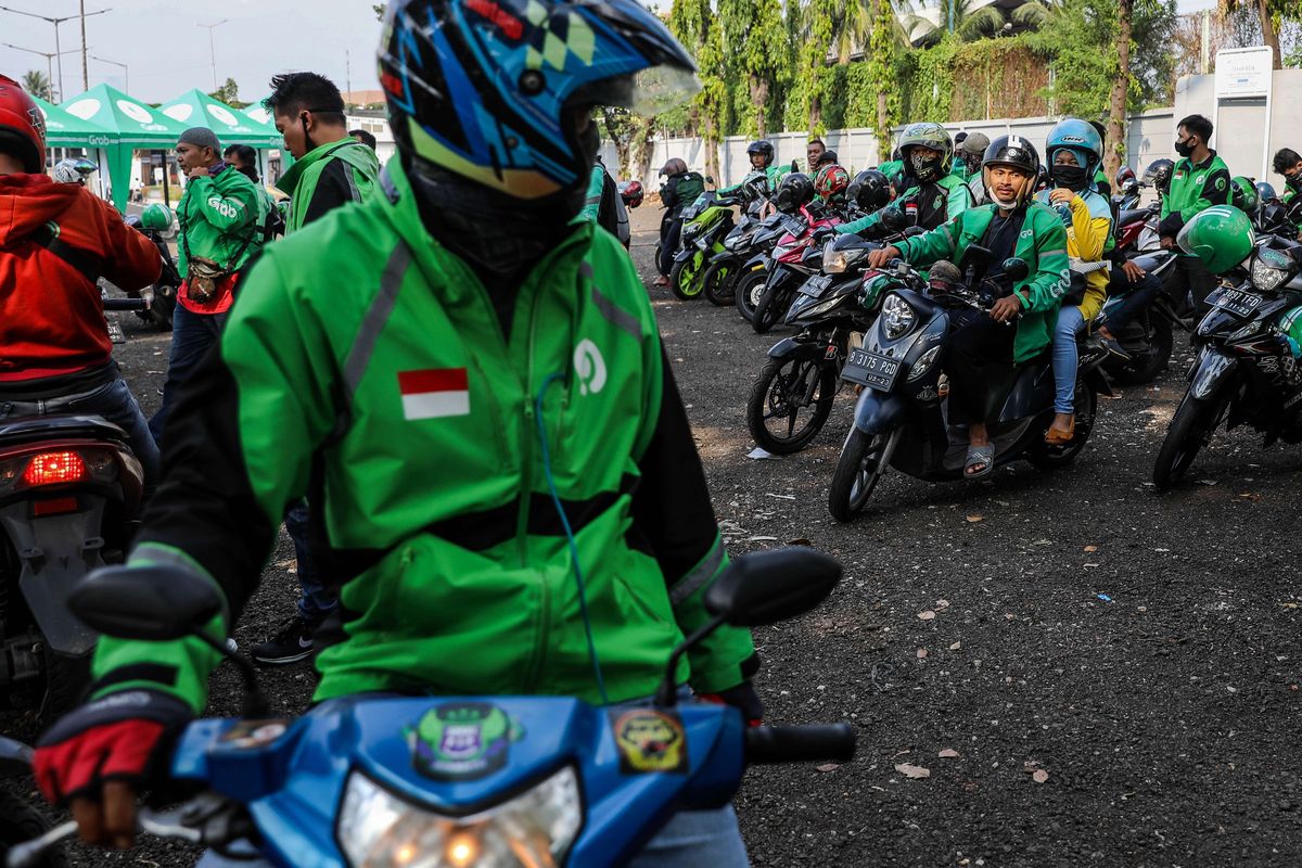 Pengemudi ojek online dengan penumpangnya di Stasiun Tanah abang, Jakarta Pusat, Senin (8/6/2020). Pemerintah Provinsi DKI Jakarta mengizinkan pengemudi ojek online beroperasi untuk mengangkut penumpang selama PSBB transisi dengan menerapkan protokol kesehatan.