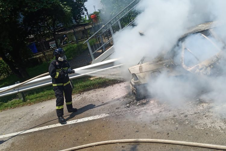 Pemadam kebakaran dari Damkar Kota Bekasi tengah memadamkan api pada mobil BMW bernomor polisi B 1223 ZER yang terbakar di pintu keluar Tol Jatiwarna, Jatisampurna, Bekasi, pada Jumat (7/4/2023).