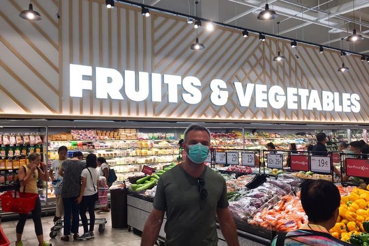 Melonjaknya kasus impor virus corona di Singapura menyebabkan meningkatnya jumlah warga yang kembali memakai masker. Salah satunya adalah seorang pria bule yang sedang berbelanja buah-buahan di supermarket FairPrice Xtra di pusat perbelanjaan VivoCity, kawasan Harbourfront, Sabtu siang (21/03/2020)