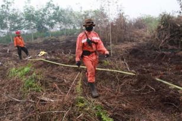 Anggota Manggala Agni Daops Singkawang melakukan pemadaman kebakaran hutan gambut di Desa Telok Ampening, Kecamatan Terentang, Kabupaten Kubu Raya, Kalbar, Jumat (25/9/2015).