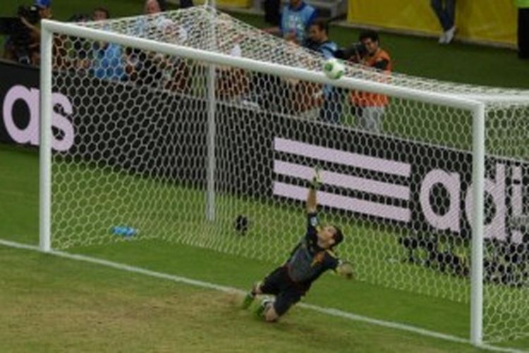 Kiper Spanyol, Iker Casillas, mencoba menghentikan bola hasil tendangan penalti Leonardo Bonucci (tak ada di gambar). Kendati gagal menghentikan bola, Casillas beruntung tendangan Bonucci melenceng jauh dari sasaran. Spanyol pun menang 7-6 atas Italia lewat adu penalti.