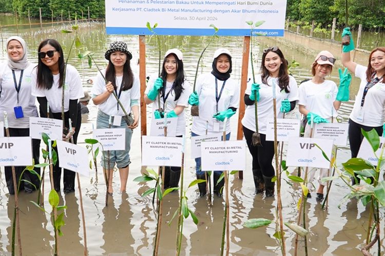Terlihat para relawan yang merupakan para karyawan Cladtek berfoto bersama menunjukkan benih mangrove yang mereka tanam dalam kegiatan Penanaman Mangrove dan Pembersihan Area di Hutan Lindung Sei Beduk, Batam, Kepulauan Riau (Kepri), Selasa (30/4/2024).