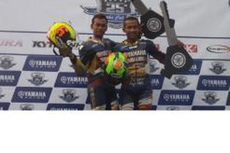 Dua pebalap tim Yamaha Suhandi Padang 88 NHK, Hapsoro Rudhito (kiri) dan Tommy Richard Orlando menerima hadiah Yamaha Jupiter Z1 atas keberhasilan mereka menjadi juara umum Yamaha Cup Race di Bangka, Minggu (7/9/2014). Hapsoro juara umum Seeded dan Tommy juara umum Pemula.