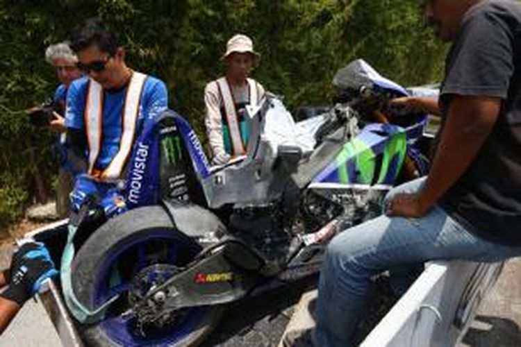 Petugas lintasan mengangkut motor milik pebalap Movistar Yamaha asal Spanyol, Jorge Lorenzo, yang rusak berat akibat kecelakaan saat menguji ban Michelin di Sirkuit Sepang, Rabu (26/2/2015).