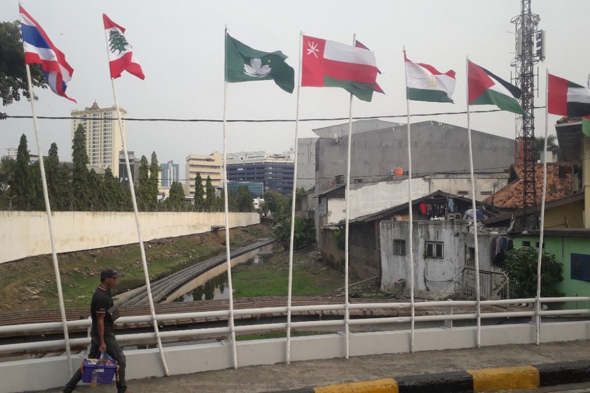 Deretan bendera negara peserta Asian Games yang dikibarkan menggunakan batang bambu di kawasan Kali Besar, Jakarta Barat, Selasa (17/7/2018).