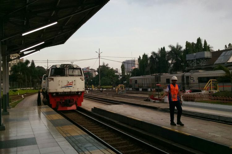 Petugas tengah membantu memberikan peringatan masinis kereta agar melaju pelan saat memasuki stasiun Bandung.