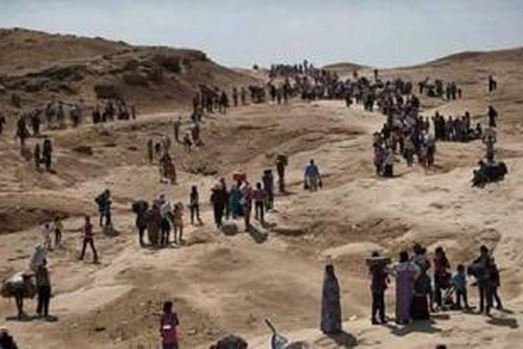 Warga kota Sinjar di Irak utara, Minggu (3/8/2014), mengungsi dari tempat tinggal mereka sejak Negara Islam yang sebelumnya bernama Negara Islam di Irak dan Suriah atau ISIS menguasai kota mereka.