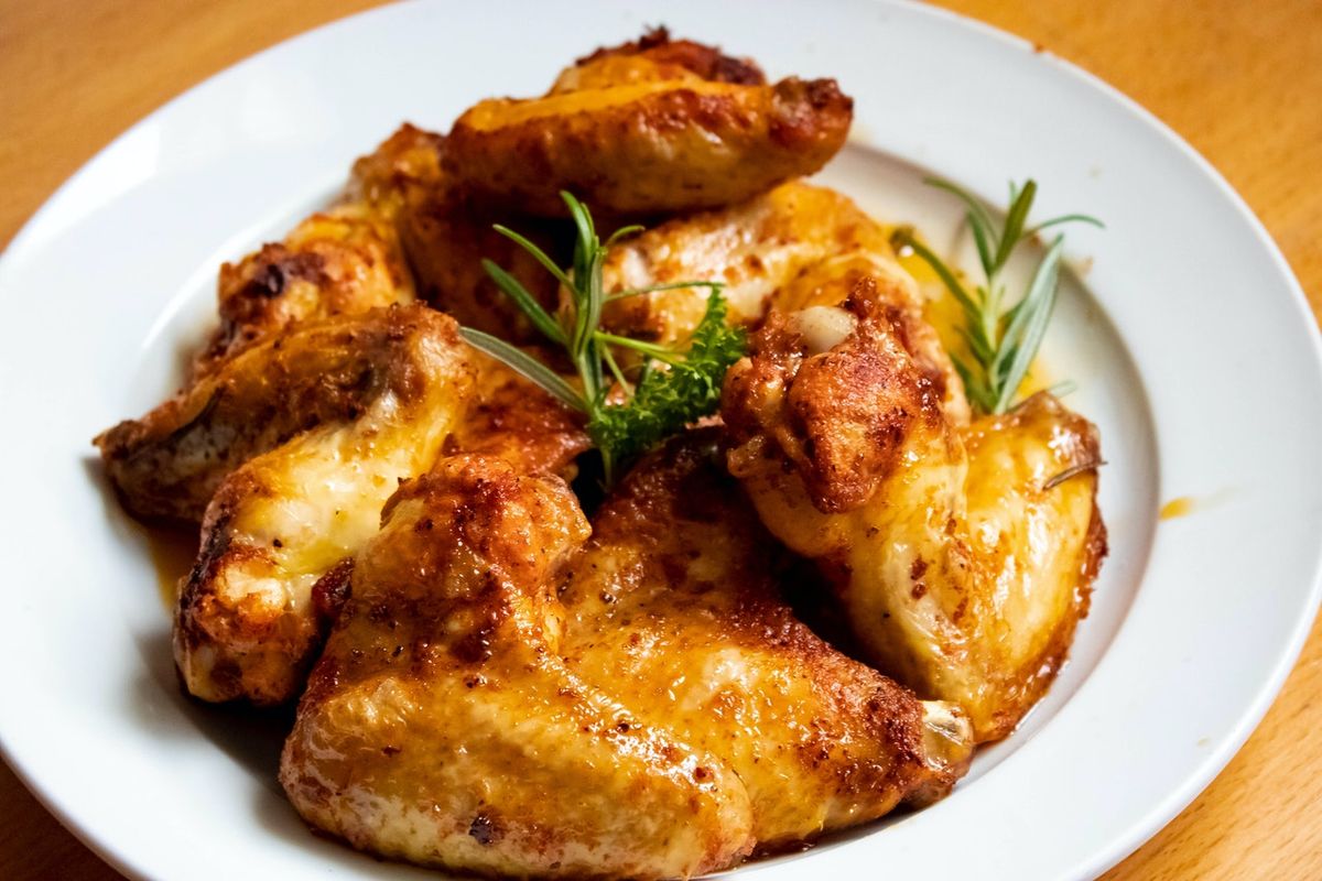 Ilustrasi sayap ayam goreng bertekstur renyah di luar dan lembut di dalam. 