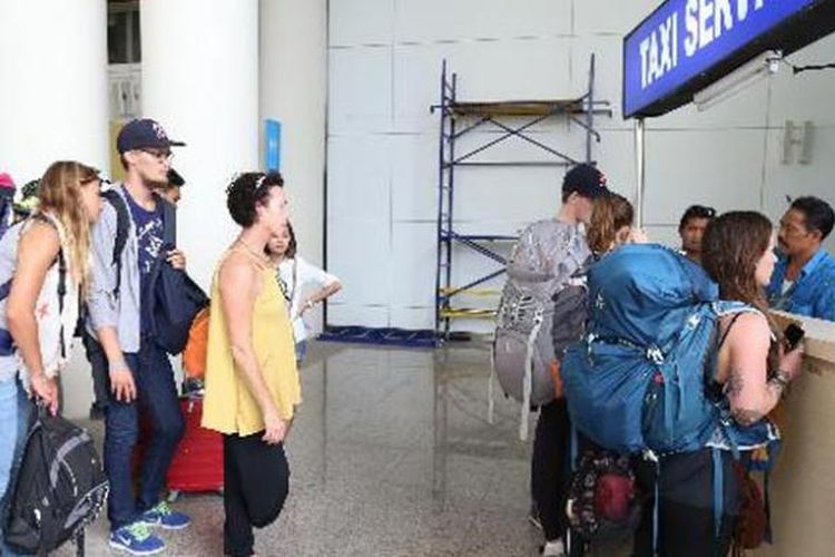 Sejumlah wisawatan sedang mengantre di loket pemesanan taksi di Bandara Ngurah Rai, Bali, Rabu (12/3/2014).   