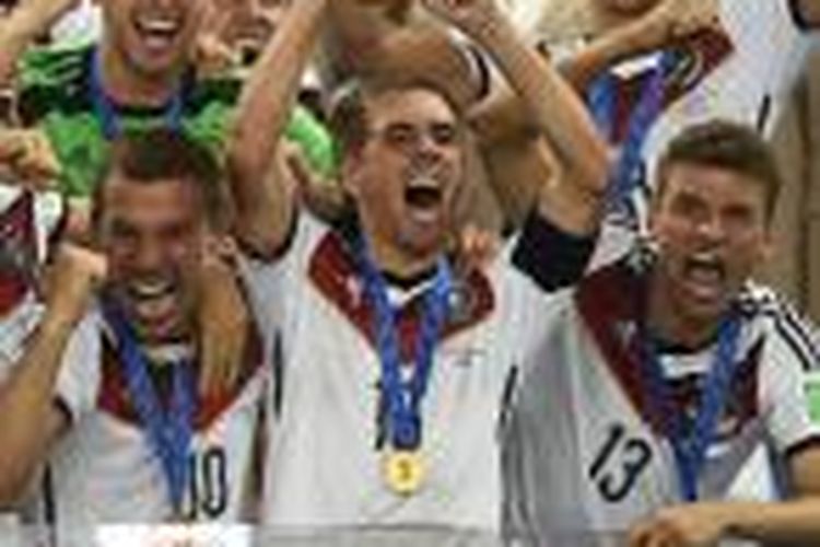 Bek sekaligus kapten Jerman, Philipp Lahm (tengah-depan) mengangkat trofi Piala Dunia 2014 setelah mereka mengalahkan Argentina 1-0 di final, Minggu (13/7/2014), lewat gol Mario Goetze pada menit ke-113 di Maracana Stadium di Rio de Janeiro, Brasil.
