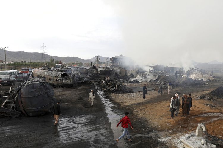 Penduduk menyaksikan sisa kebakaran tangki minyak dan truk di Kabul, Afghanistan, Minggu, 2 Mei 2021. 