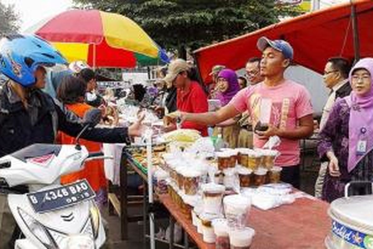 Pembeli berbelanja menu takjil di Jalan Panjang, Kebon Jeruk, Jakarta Barat, Selasa (30/6). Namun, selain menggerakkan perekonomian rakyat, aktivitas jual-beli di jalan tersebut juga mengganggu lalu lintas kendaraan.
