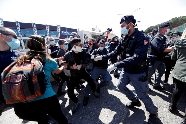 Polisi menahan gerak massa yang berdemonstrasi di luar penjara Rebibbia. Demonstran menuntut lingkungan yang lebih bersih di dalam penjara, di tengah merebaknya pandemi virus corona di Italia. Foto diambil pada 16 April 2020.