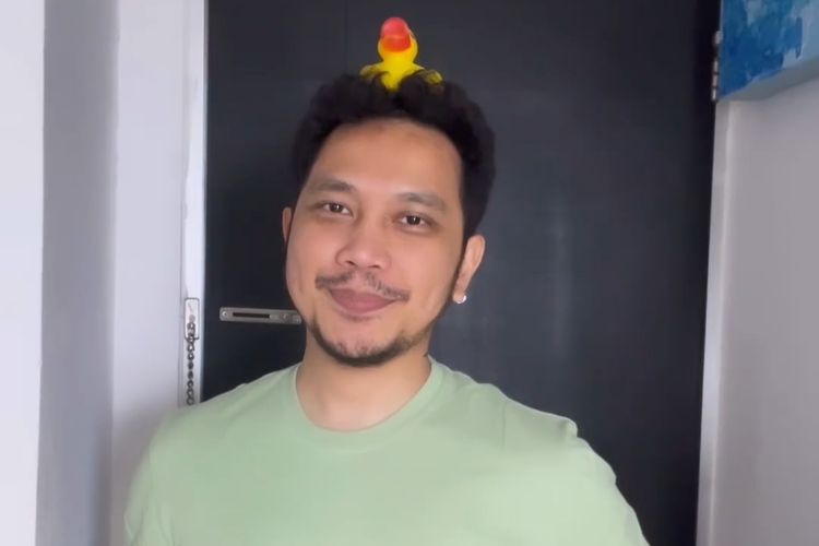 Seleb Instagram dan seleb TikTok Agung Karmalogy yang berpenampilan khas dengan bebek mainan di atas kepalanya.