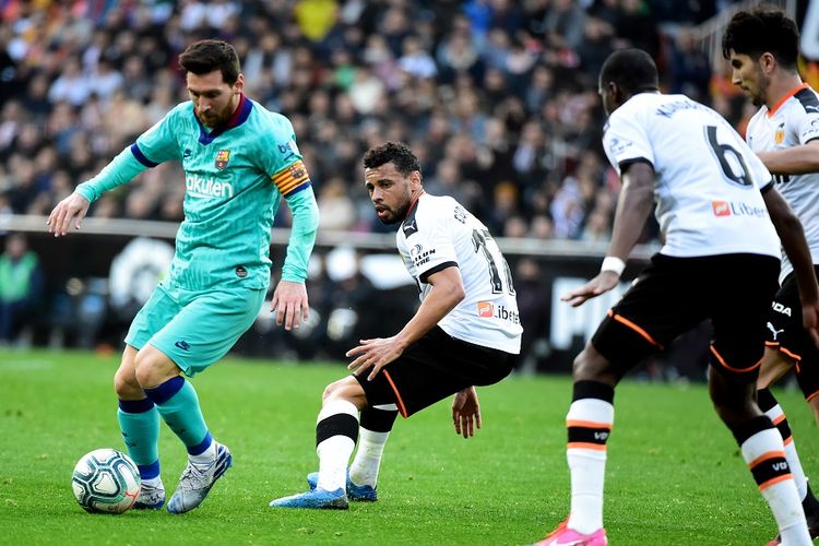 Penyerang Barcelona Lionel Messi (kiri) mengontrol bola dalam pertandingan La Liga Spanyol Valencia vs Barcelona di Stadion Mestalla di Valencia pada 25 Januari 2020.