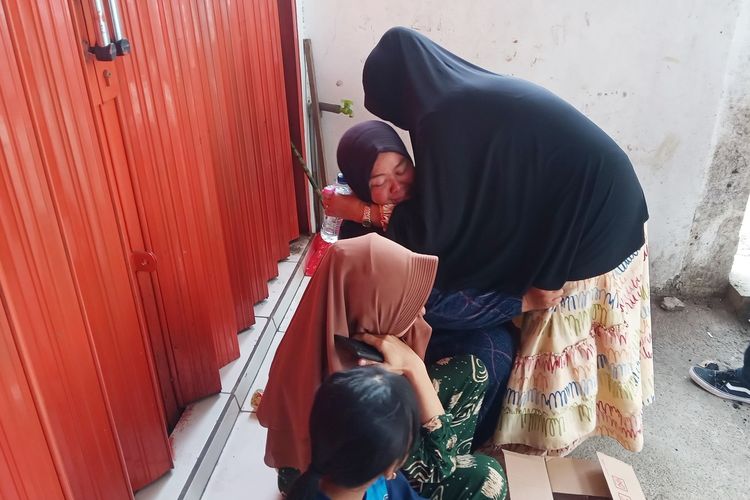 Kerabat tersangka Sugeng Guruh (41) berupaya menenangkan kakak kandung tersangka yang menangis histeris di lokasi rekonstruksi ulang kasus tabrak lari mahasiswi Cianjur, Selasa (21/2/2023).
