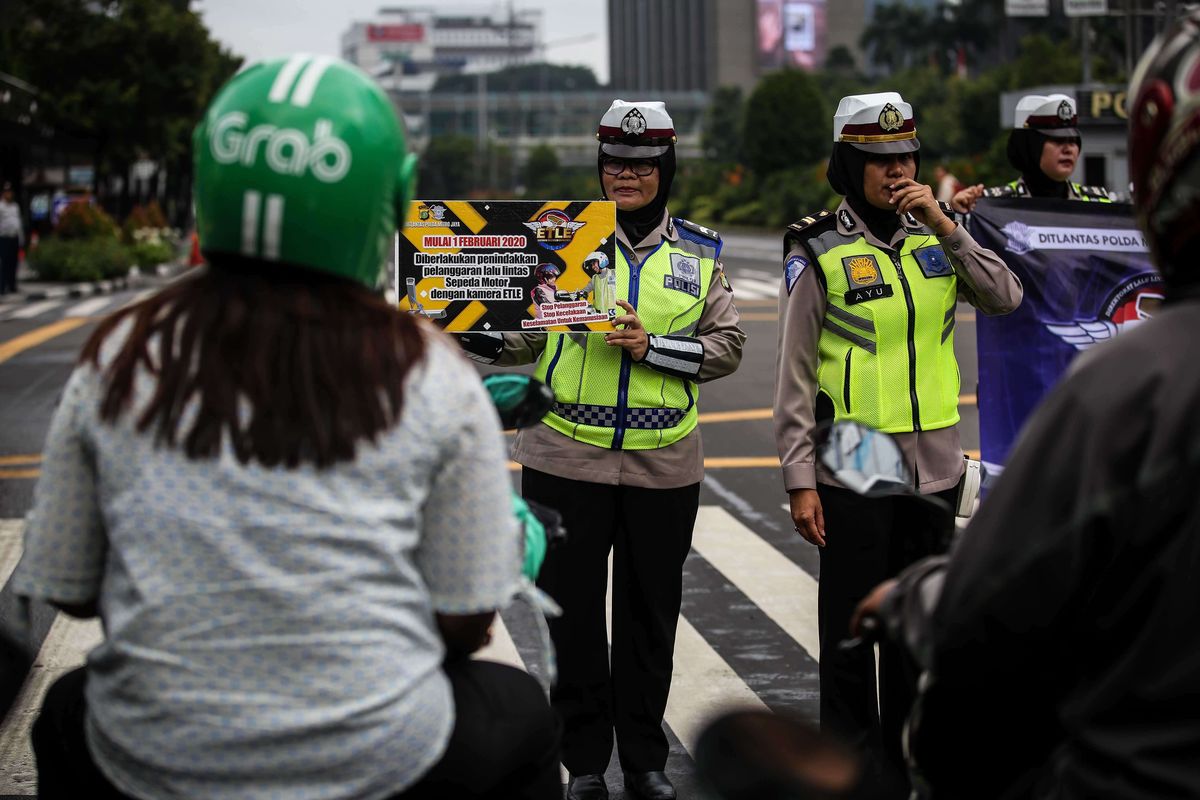 Petugas kepolisian dari direktorat lalu lintas (Ditlantas) Polda Metro Jaya menyosialisasikan penerapan sistem tilang elektronik atau electronic traffic law enforcement (ETLE) untuk kendaraan roda dua atau motor di Simpang Sarinah, Thamrin, Jakarta Pusat, Senin (3/2/2020). Untuk saat ini sistem ETLE untuk pengendara sepeda motor fokus pada penindakan tiga pelanggaran, yakni penggunaan helm, menerobos traffic light, dan melanggar marka jalan. Penerapan aturan tersebut telah resmi diberlakukan mulai Sabtu (1/2/2020).