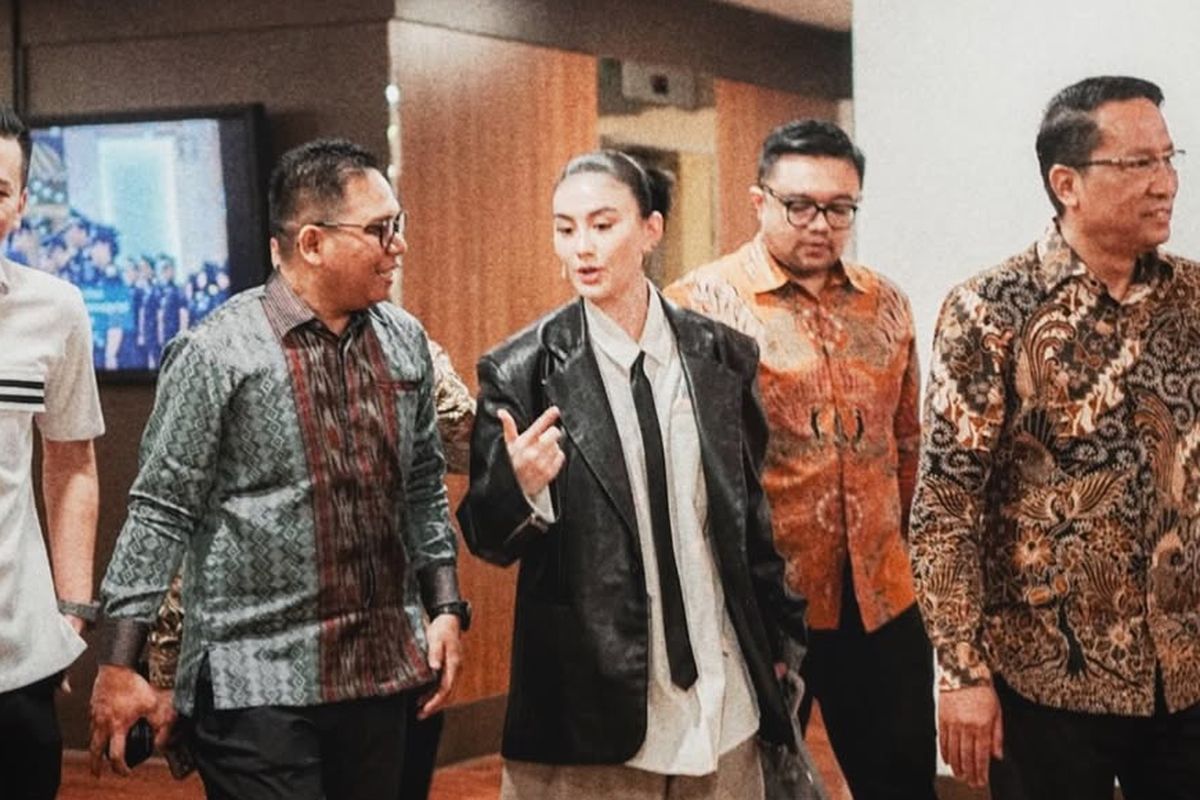 Gaya Agnez Mo mengenakan kemeja putih, leather blazer, dan dasi. 