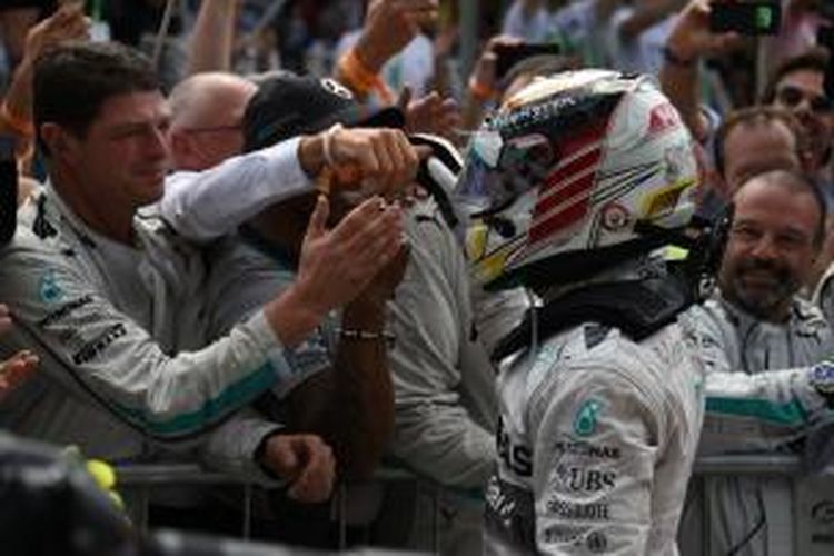 Pebalap Mercedes asal Inggris, Lewis Hamilton (kanan) merayakan dengan timnya setelah finis kedua pada balapan GP Brasil di Sirkuit Interlagos, Minggu (9/11/2014).