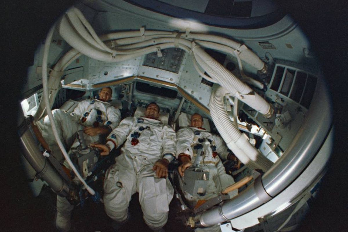 Tiga orang astronot Apollo 12,  Bean, Gordon, dan Conrad terlihat melalui lensa mata-ikan di dalam Command Module simulator.