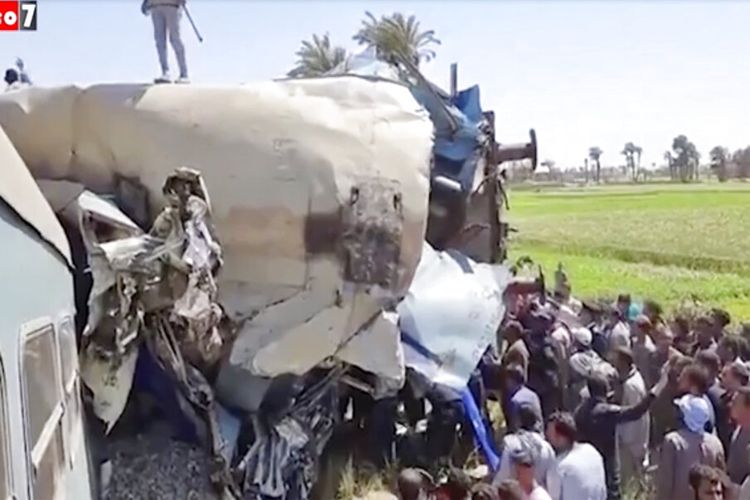 Gambar yang disediakan oleh Youm7 ini menunjukkan kerumunan orang berkumpul di sekitar gerbong kereta yang hancur di lokasi kecelakaan kereta api di Mesir, Jumat (26/3/201). Dua kereta bertabrakan setelah seseorang diduga mengaktifkan rem darurat, menewaskan beberapa orang dan menyebabkan lainnya terluka.