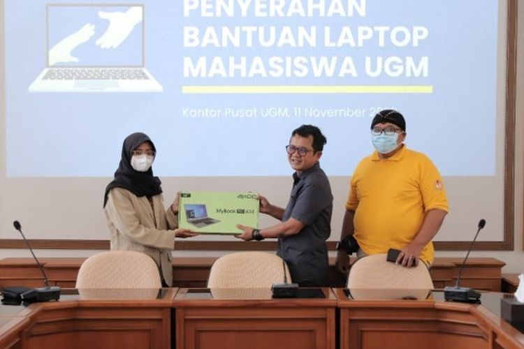 Arie Sujito (tengah) menyerahkan bantuan peminjaman laptop pada mahasiswa KIP Kuliah.