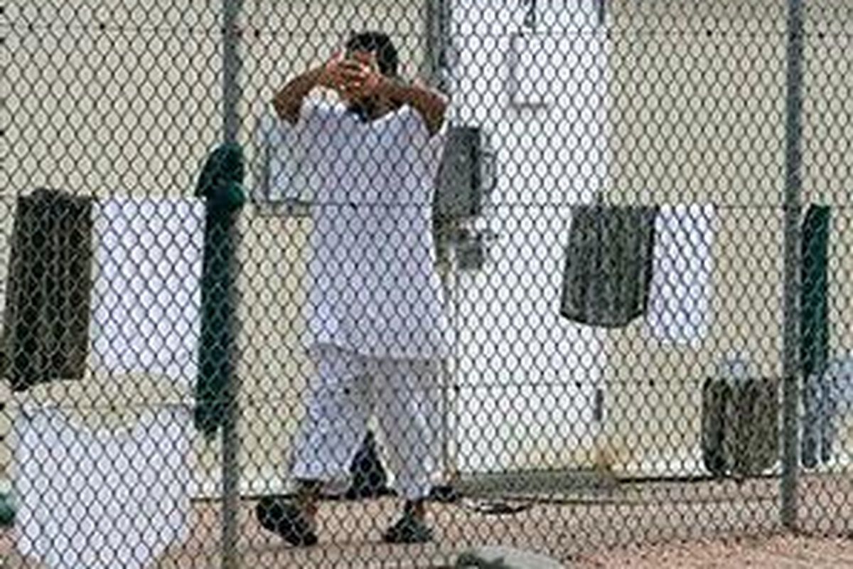 Seorang tahanan di Guantanamo menutupi wajahnya. Di kamp penjara ini ratusan tersangka terorisme ditahan tanpa pengadilan.