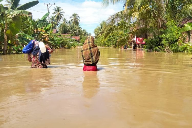 Warga saat melintas di Desa Kalepu, Mamuju, Sulbar, yang sudah terendam banjir, Selasa (9/5/2023).