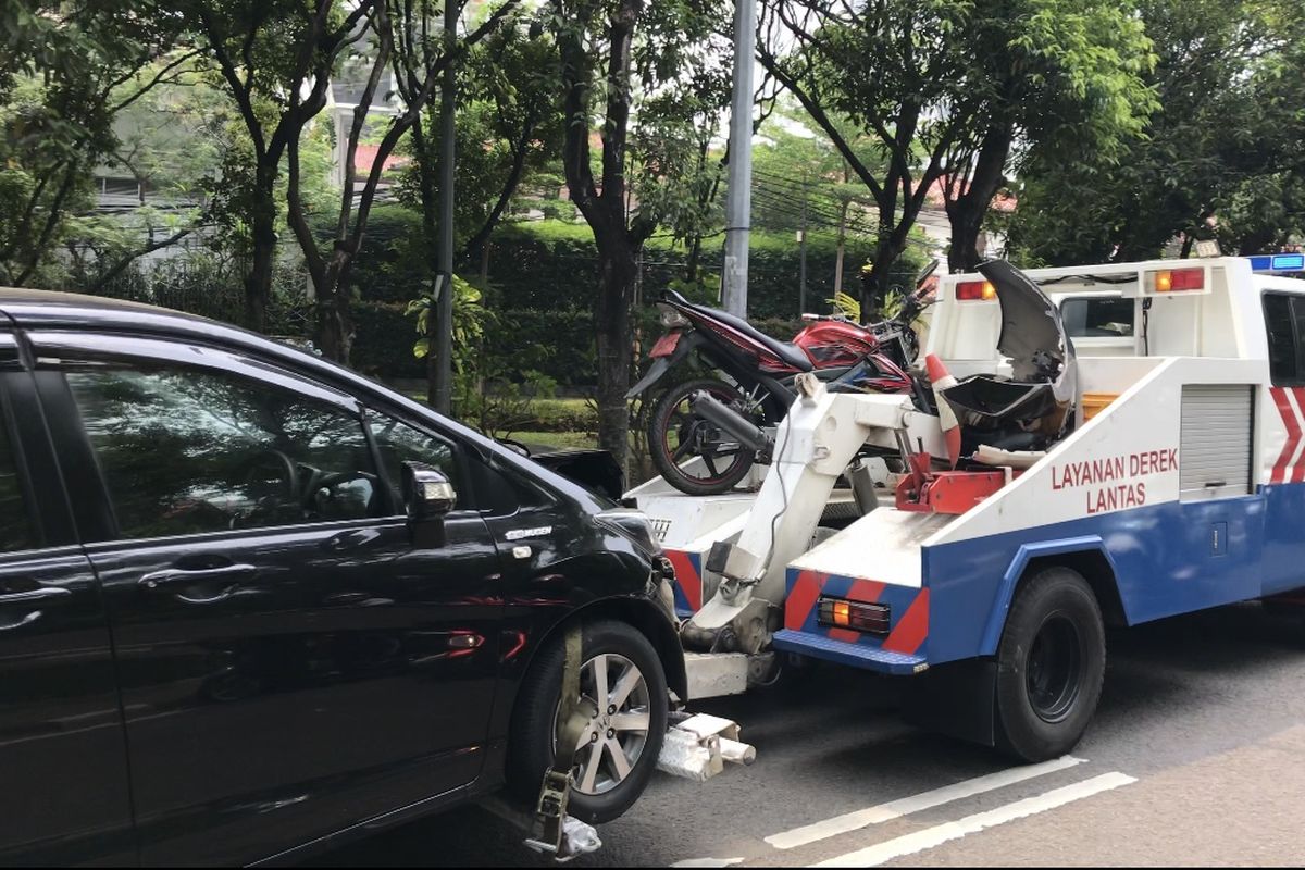 Mobil derek membawa mobil dan motor yang terlibat kecelakaan di Jalan Dharmawangsa Raya tepatnya di dekat Sanatorium Dharmawangsa, Pulo, Kebayoran Baru, Jakarta Selatan pada Senin (30/8/2021) siang.