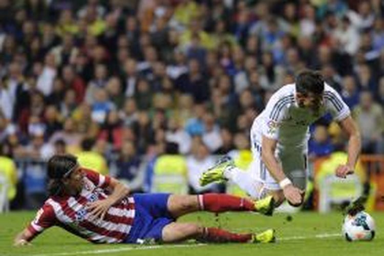 Winger Real Madrid asal Wales, Gareth Bale (kanan), berjibaku dengan bek Atletico Madrid asal Brasil, Filipe Luis, dalam derbi Madrid di Santiago Bernabeu, Sabtu (28/9/2013). Dalam laga ini Atletico menang 1-0 dan mereka untuk pertama kalinya menang di ajang La Liga di kandang Madrid setelah 14 tahun silam.