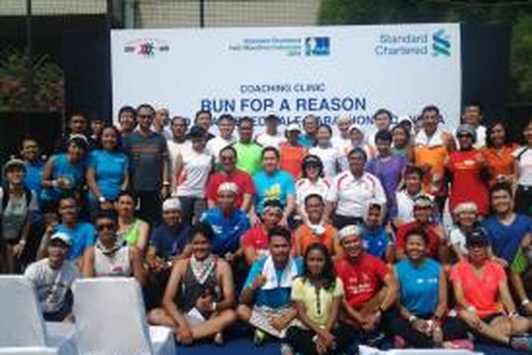 Pelari nasional, Triyanigsih (depan baju kuning), foto bersama para peserta coaching clinic Standard Chartered Half-Marathon di Tennis Court Hotel Sultan, Senayan, Jakarta, Sabtu (8/11/2014).