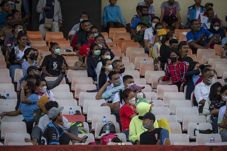 Warga menyaksikan pertandingan babak enam besar sepak bola putra PON XX Papua 2021 antara Tim Papua melawan Tim Aceh di Stadion Mandala, Kota Jayapura, Papua, Rabu (6/10/2021). Sejumlah laporan dari PON XX Papua menunjukkan sebagian penonton yang hadir di venue pertandingan ditemukan masih lalai terhadap protokol kesehatan, seperti tidak mengenakan masker dan mengabaikan pembatasan jarak.