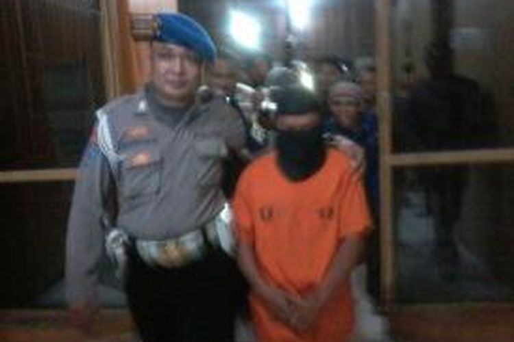 Pelaku Lukman digelandang polisi saat diamankan di markas Polrestabes Makassar, Jumat (9/5/2014).