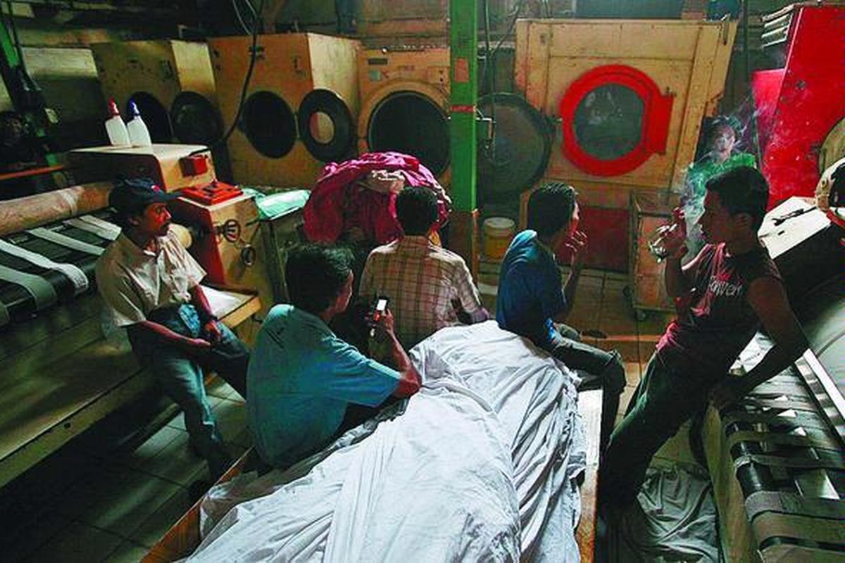 Pekerja laundry Saporette menunggu waktu di antara cucian yang menumpuk karena pemadaman bergilir di kawasan Kemanggisan, Jakarta Barat, Rabu (11/11). Akibat pemadaman lebih dari 4 jam, pemilik laundry harus menanggung rasa kecewa pelanggannya yang terdiri dari sejumlah hotel akibat cucian terlambat dan biaya ekstra lembur 30 karyawannya untuk bekerja hingga pagi.