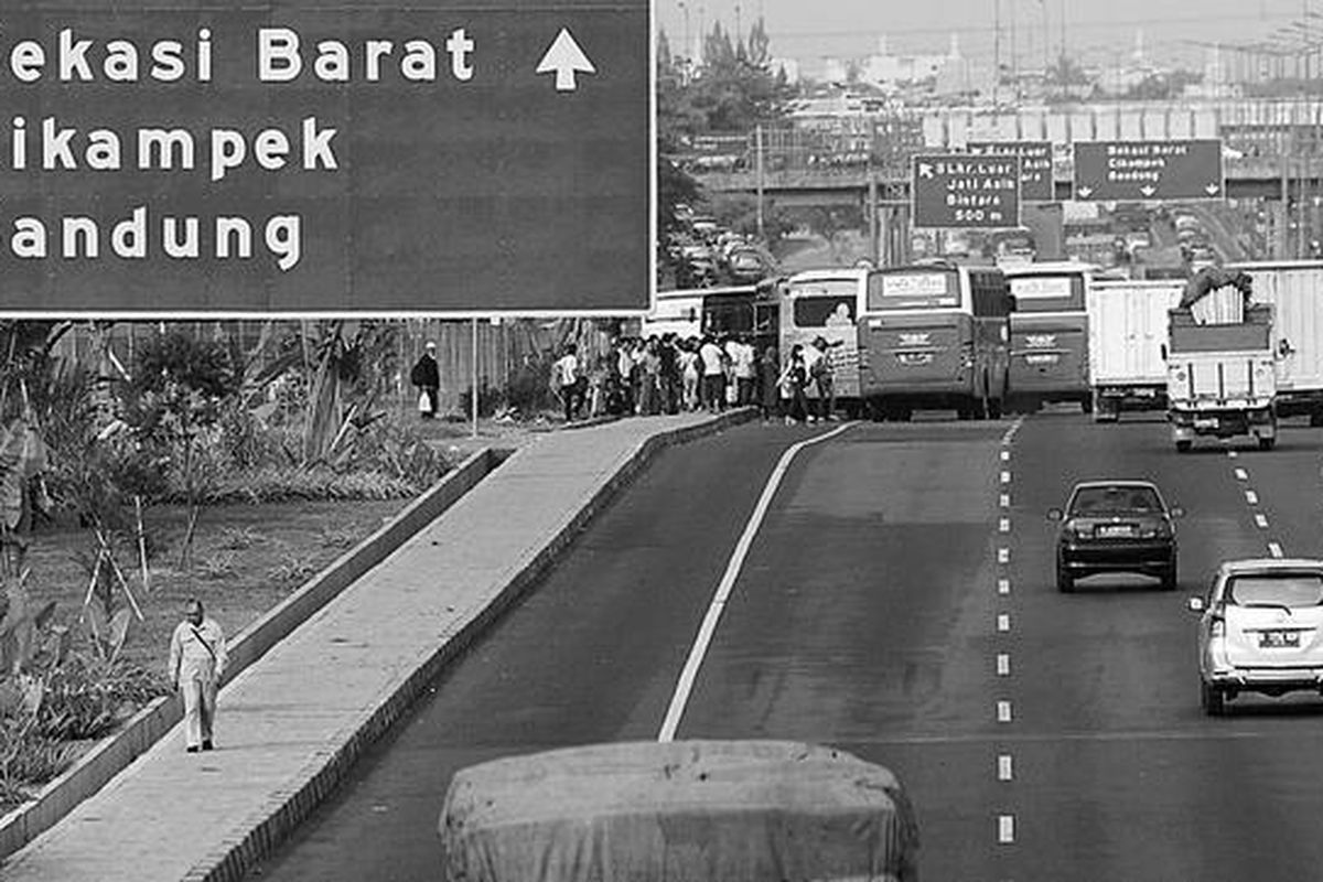 Penumpang turun dan menunggu bus di terminal bayangan di ruas Tol Jakarta-Cikampek Kilometer 8, Jatibening, Pondok Gede, Kota Bekasi, Sabtu (28/7). Terminal bayangan kembali digunakan setelah hari Jumat terjadi kerusuhan akibat penutupan akses oleh PT Jasa Marga (Persero) selaku pengelola jalan Tol Jakarta-Cikampek. Perhitungan Jasa Marga, mulai pukul 06.00 hingga 14.00, sebanyak 936 kendaraan menaikturunkan penumpang di lokasi tersebut.
