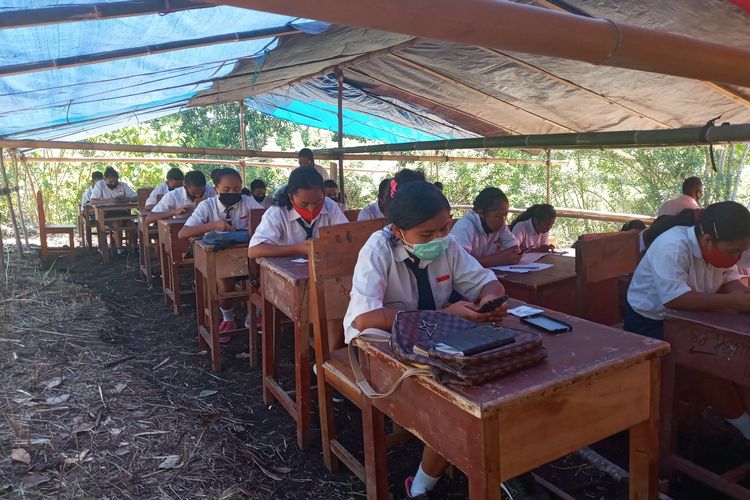 sebanyak 47 siswa dan siswi SMPN 04 Kota Komba melaksanakan Ujian Akhir Sekolah (UAS) berbasis digital dibawah tenda darurat di tengah hutan di Gunung Wokonggoro, Kampung Gurung, Desa Gunung, Kecamatan Kota Komba, Kabupaten Manggarai Timur, NTT, Senin, (12/4/2021). Ujian dilaksanakan dari Senin, (12/4/2021) sampai Kamis, (15/4/2021). (KOMPAS.com/MARKUS MAKUR)