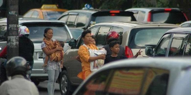 Seorang joki 3 in 1 menawarkan jasa kepada pengendara mobil yang lewat di ruas Jalan Gatot Subroto, Slipi, Jakarta, Selasa (28/9/2010). 