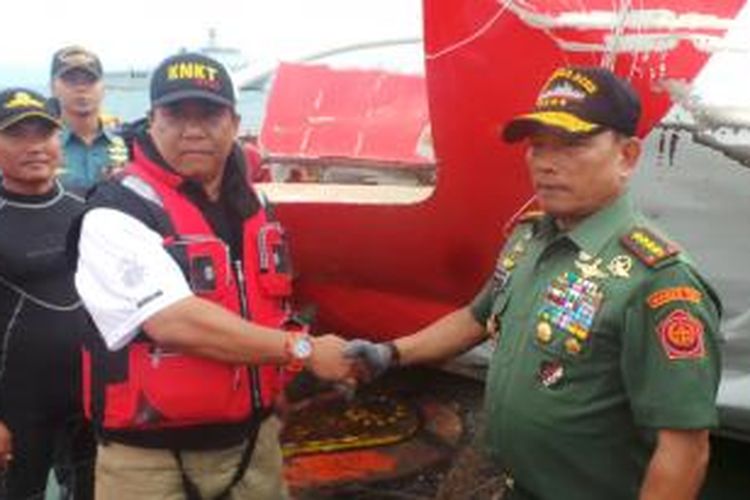 Panglima TNI Jenderal Moeldoko menyerahkan ekor pesawat AirAsia AZ8501 ke Kepala Staf Laboratorium Komisi Nasional Keselamatan Transportasi (KNKT) Andreas Hatanto (kiri) di kapal Crest Onyx, Sabtu (10/1/2015).
