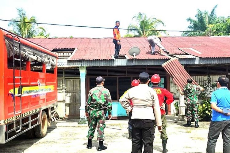 Prajurit TNI bersama kepolisian dan BPBD memperbaiki rumah warga yang rusak akibat angin puting beliung di Kecamatan Kepenuhan Hulu, Kabupaten Rokan Hulu, Riau, Sabtu (6/5/2023).