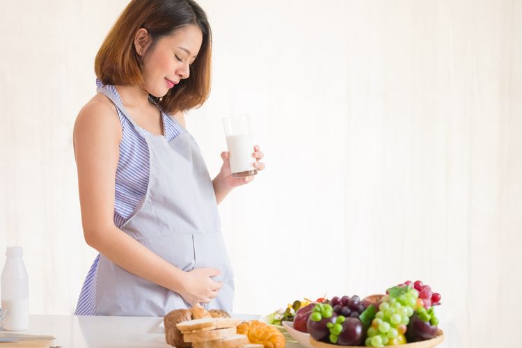Ilustrasi ibu hamil menjaga kehamilan dengan mengonsumsi makanan dan minuman bernutrisi. 