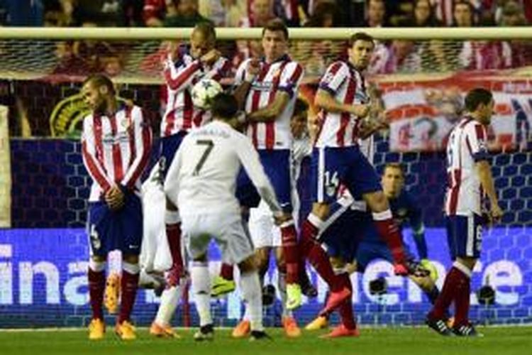 Penyerang Real Madrid, Cristiano Ronaldo (tengah), mengeksekusi tendangan bebas saat melawan Atletico Madrid, pada pertandingan leg pertama perempat final Liga Champions di Vicente Calderon, Selasa atau Rabu (14/4/2015) dini hari WIB. 