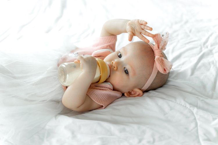 Ilustrasi bayi minum susu dari botol.