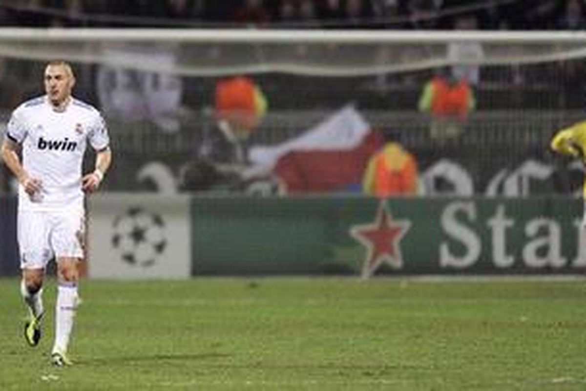 Ekspresi penyerang Real Madrid, Karim Benzema (kiri), usai membobol gawang Lyon, pada leg pertama 16 besar Liga Champions, Selasa (22/2/2011).