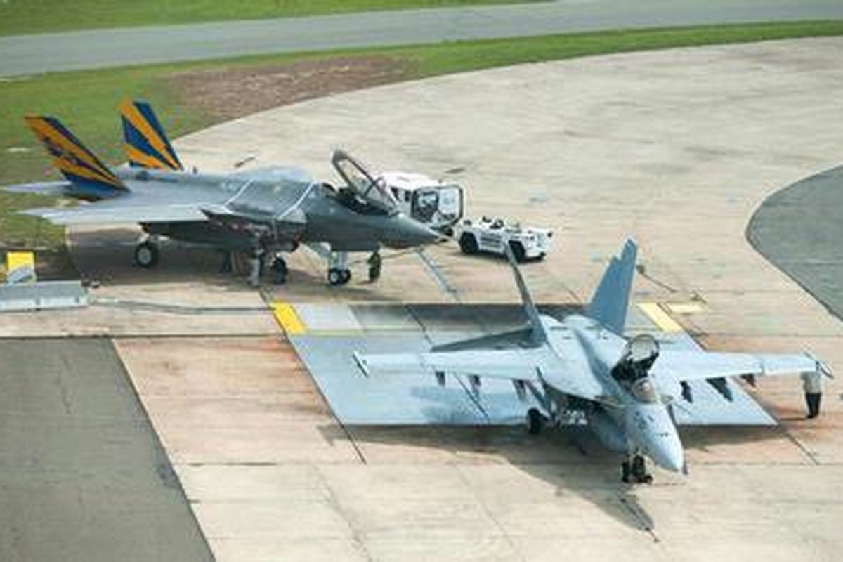 Pesawat F-35C varian kapal induk (belakang), yang akan menggantikan peran pesawat seri F/A-18 (depan), yang selama ini diandalkan Angkatan Laut AS.