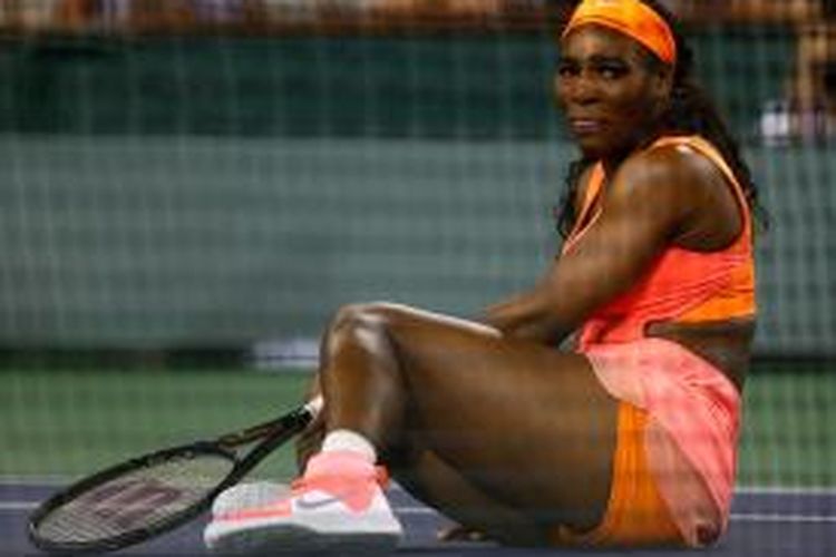 Petenis Amerika Serikat, Serena Williams, terjatuh saat berusaha mengambalikan bola dari petenis Rumania, Monica Niculescu, pada babak kedua BNP Paribas Terbuka di Indian Wells, Jumat (13/3/2015).