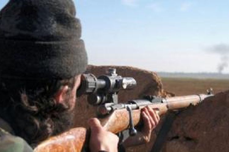 Seorang tentara militan mengarahkan senapannya pada pertempuran di Tal Tamr, Provinsi Hassakeh, Suriah, pada foto yang dipasang oleh divisi Al-Baraka kelompok Negara Islam pada 24 Februari lalu. 