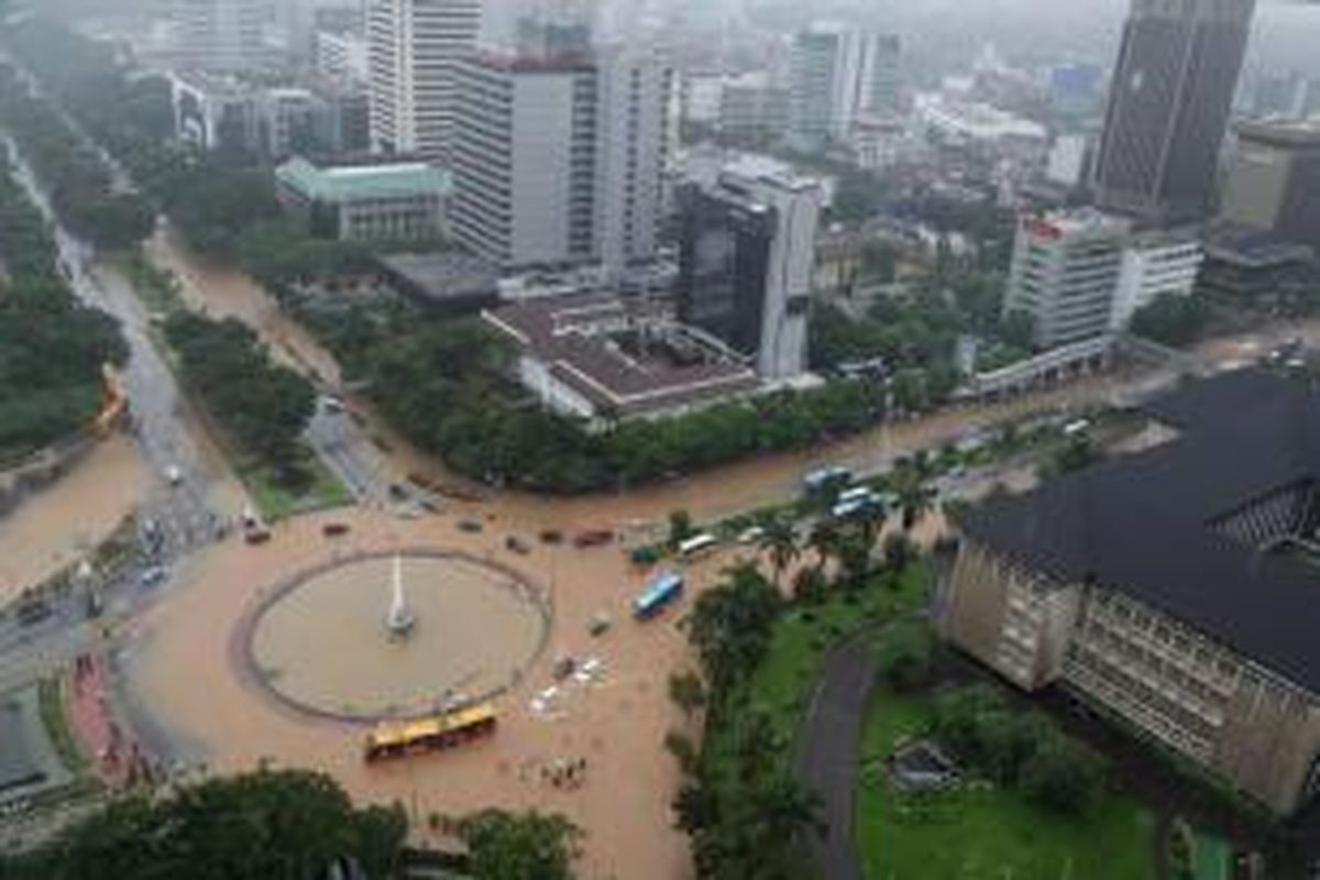 Banjir di kawasan bundaran air mancur di samping Patung Arjuna Wiwaha, Jalan MH Thamrin, Jakarta, Senin (9/2/2015). Curah hujan yang tinggi mengakibatkan sejumlah tempat di ibu kota terendam banjir. KOMPAS / LASTI KURNIA
